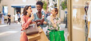 Friends enjoying ice cream cones and shopping bags.