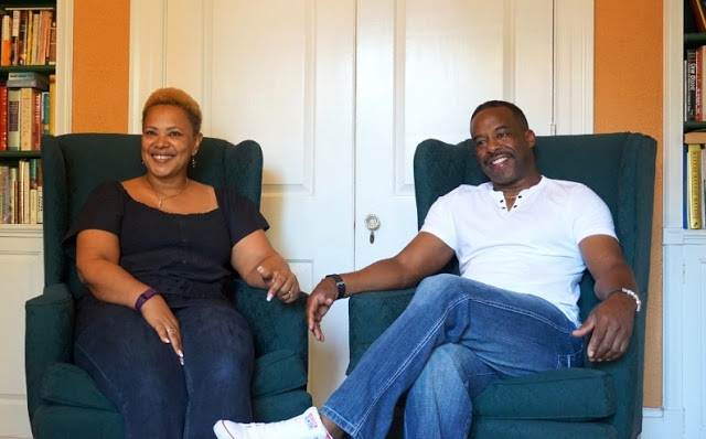 Innkeepers Monica & Daniel Edwards sitting in high back queen anne styled green chairs